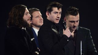 LONDON, ENGLAND - FEBRUARY 19:Alex Turner, Jamie Cook, Nick O'Malley and Matt Helders of Arctic Monkeys receive the award for the MasterCard British Album of the Year at The BRIT Awards 2014