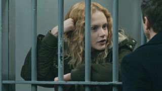 Emma Laird as Iris leaning against a prison cell and talking to Jeremy Renner's Mike in Season 3 of Mayor of Kingstown.