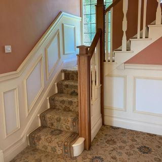Carpeted hallway with a staircase and panelled walls