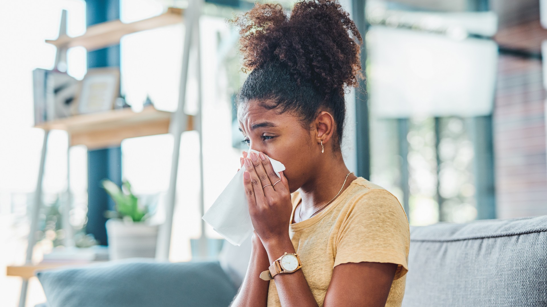 Woman with allergies blowing her nose