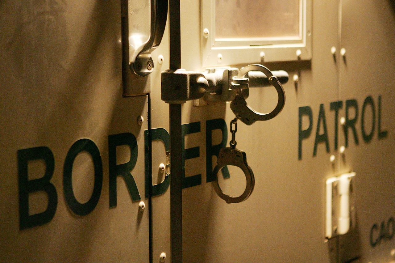 Handcuffs hang on the back of a border patrol van.