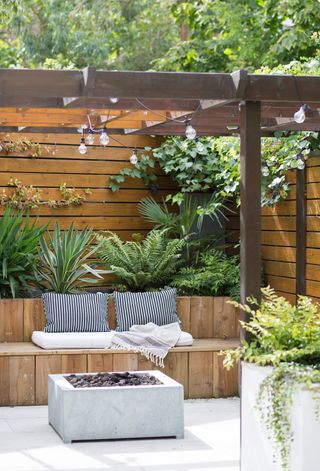 Garden fence and pergola used to create built-in outdoor seating area