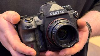 a Pentax K-3 Mark III Monochrome camera held in the hands