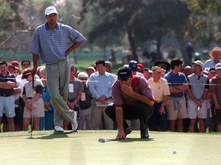 Nick Faldo reading a putt in front of Tiger Woods