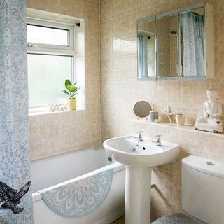 tiled bathroom with bathtub and washbasin