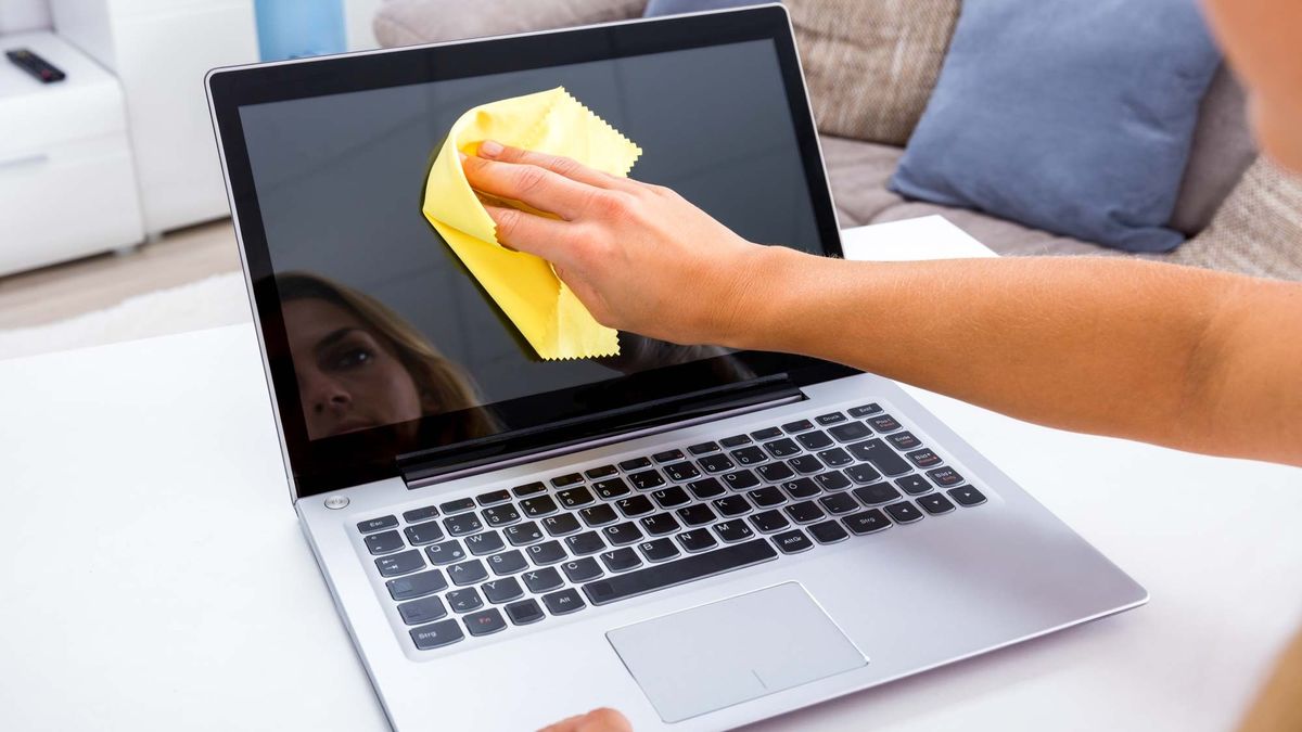 Old laptop being cleaned by woman