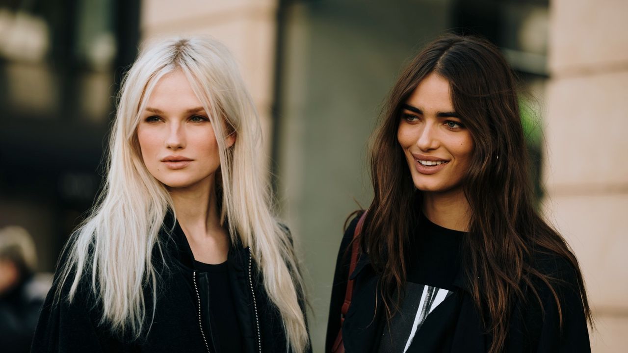 blonde and brunette women with shiny hair in a city 