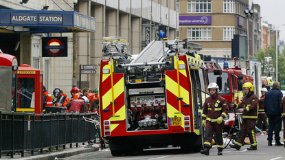 Police and fire officers work outside London&#039;s Aldgate East tube station after an explosion occurred on 7 July 2005