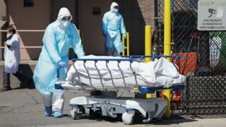 Bodies of COVID-19 victims are moved to a refrigerated truck serving as a temporary morgue at Wyckoff Hospital in Brooklyn, New York, on April 6, 2020.