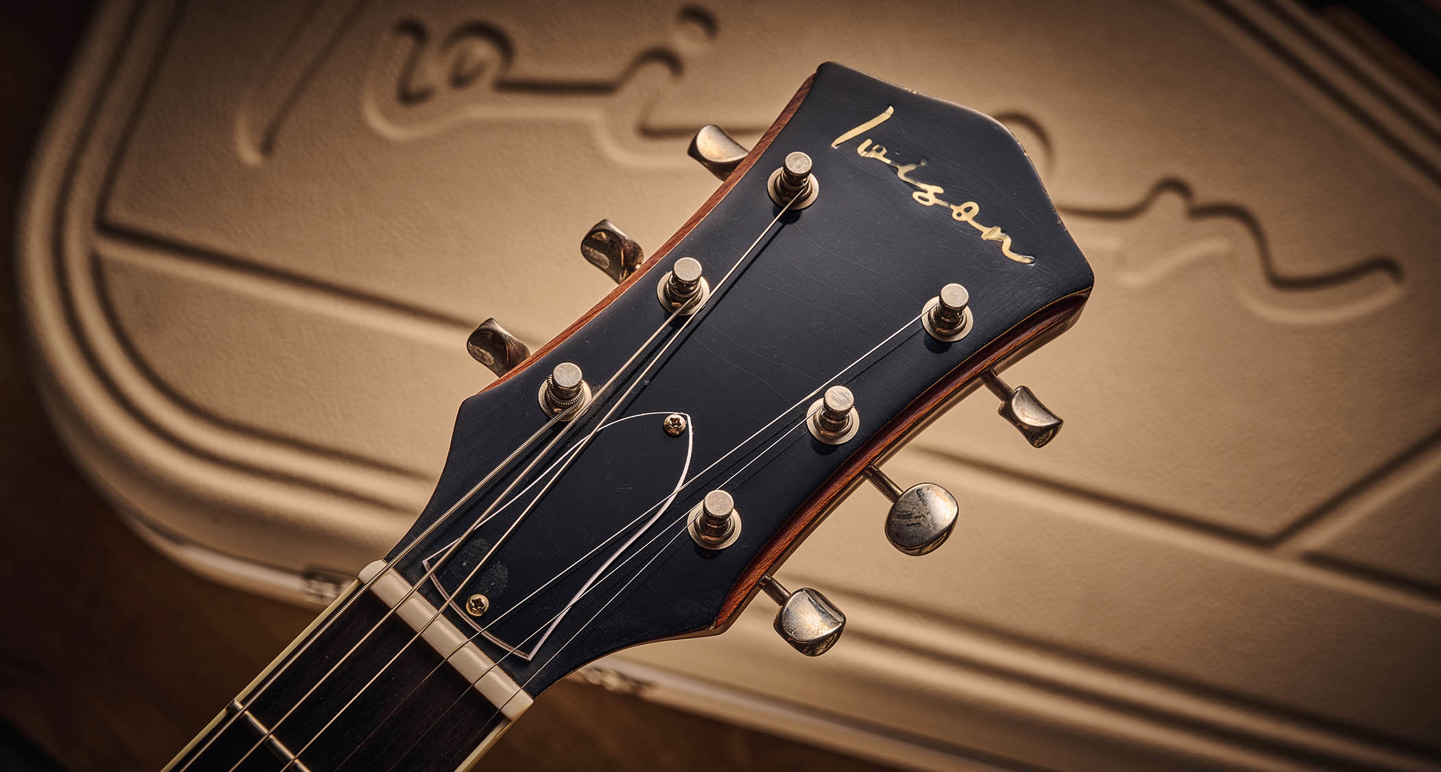 Ivison Dakota Standard in Cadillac Green photographed against its cream-covered Hiscox hard-shell guitar case.