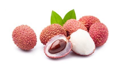 close up of several lychee fruits with one cut open 