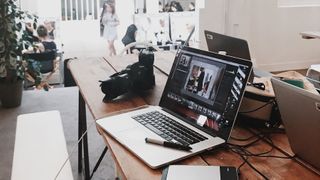 best laptops for photo editing - A camera next to a laptop on a desk.