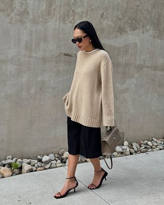 @dawn.tan wearing Bermuda shorts, oversized jumper and strappy heels