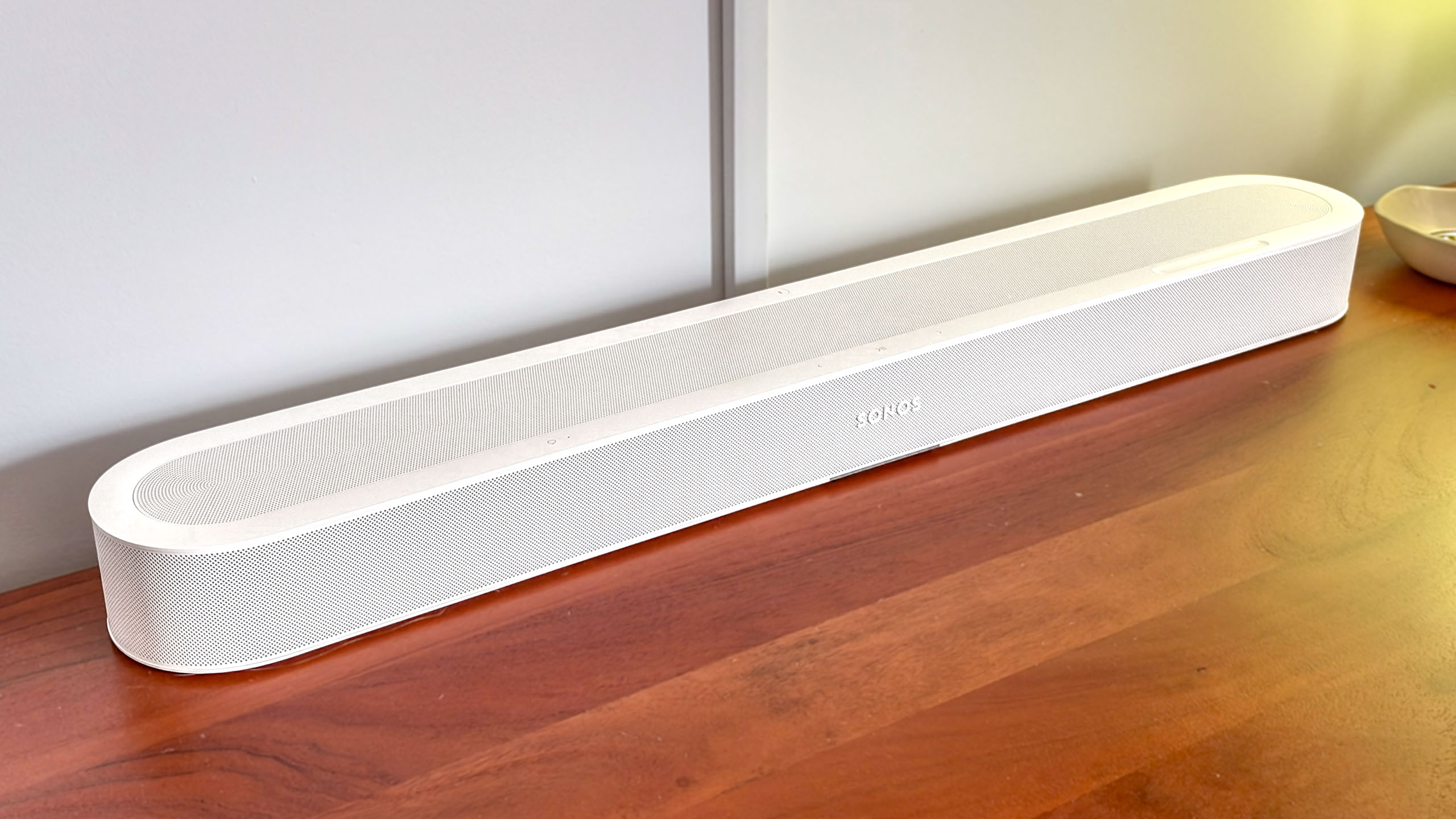 A Sonos Beam Ultra soundbar on a side table