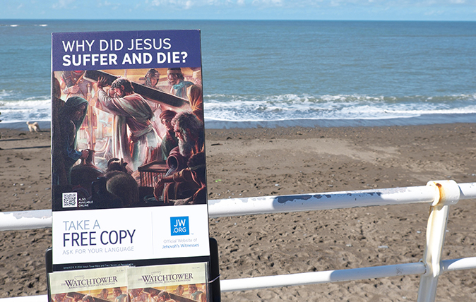 FW8HBH Copies of the Watchtower religious magazine published by Jehovah&#039;s Witnesses on promotion at Aberystwyth seafront Wales.