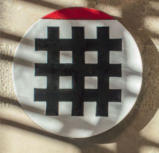 Enamel white plate, with a red top, and three thick black lines going vertically and horizontally in the center.