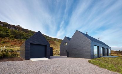 Abstracted shed with oiled Siberian larch cladding and aluminium roof sheeting on the Isle of Skye.