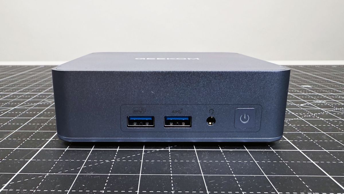 Close up of the front ports on the Geekom AX8 Pro AI Mini PC on a black mat against a white background.
