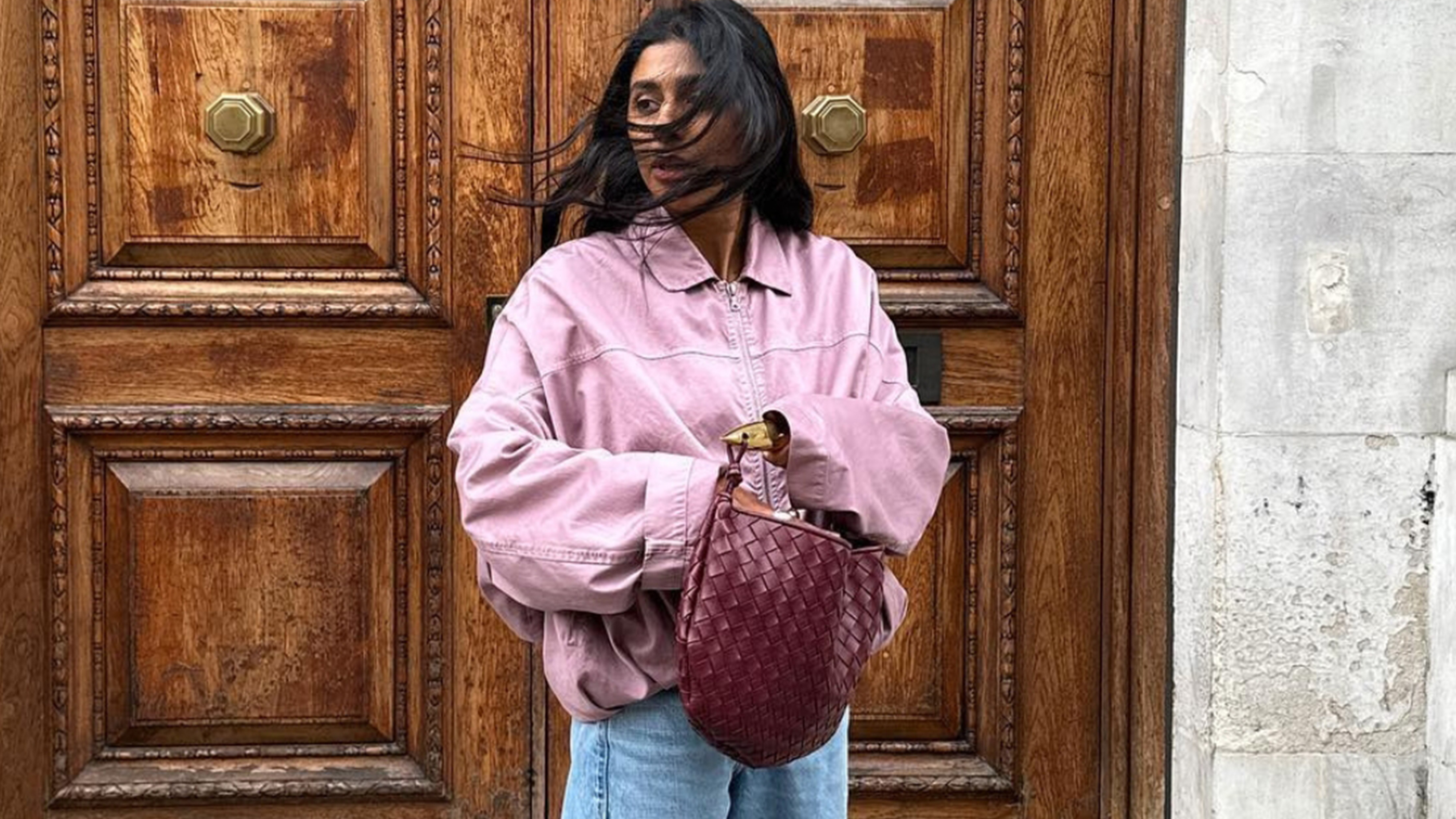 Monikh wearing a bomber jacket and jeans.