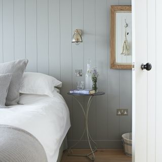 bedroom with bed with white sheets and tongue and groove panelling