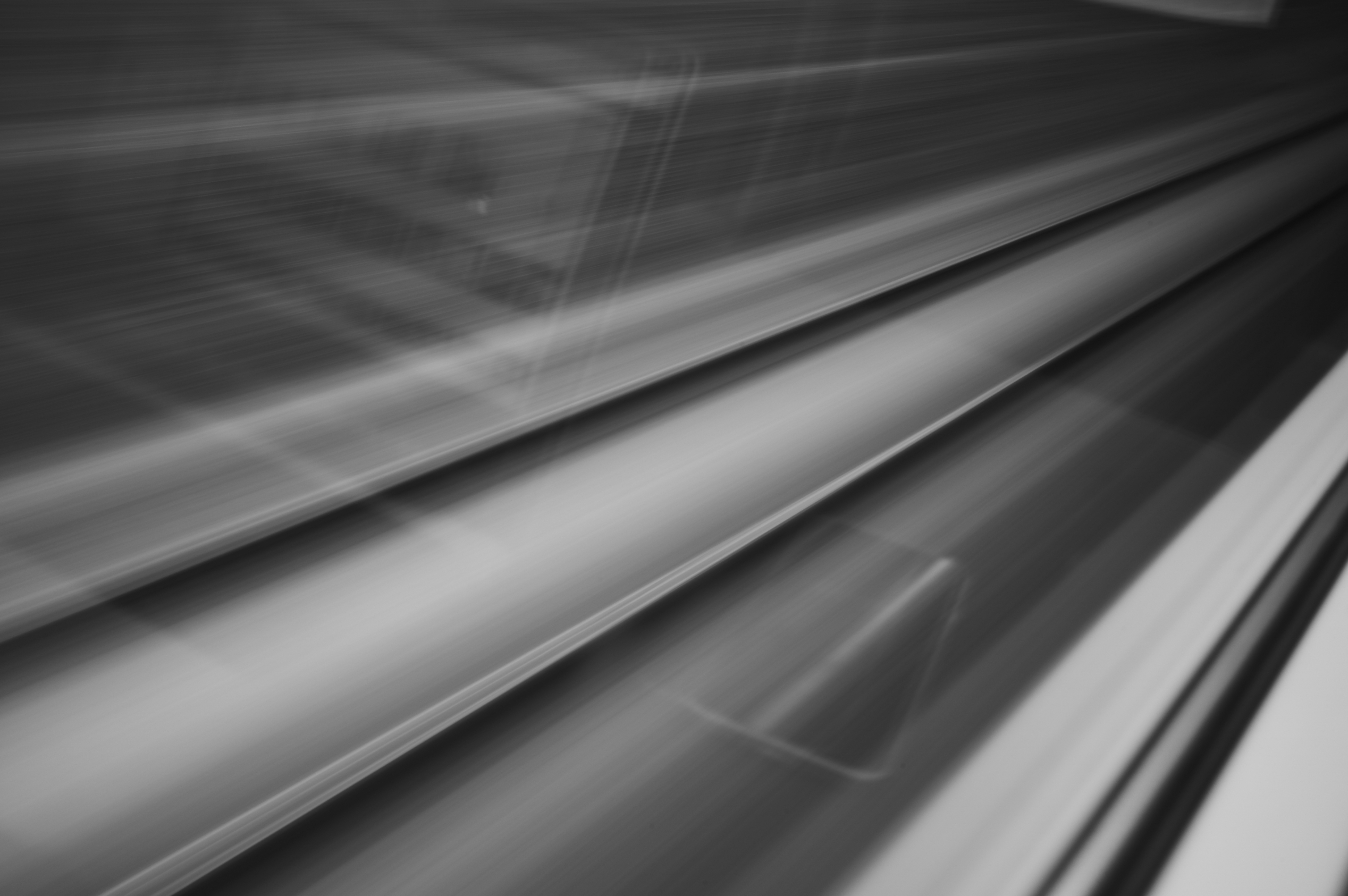 Blurred train tracks moving past a train window