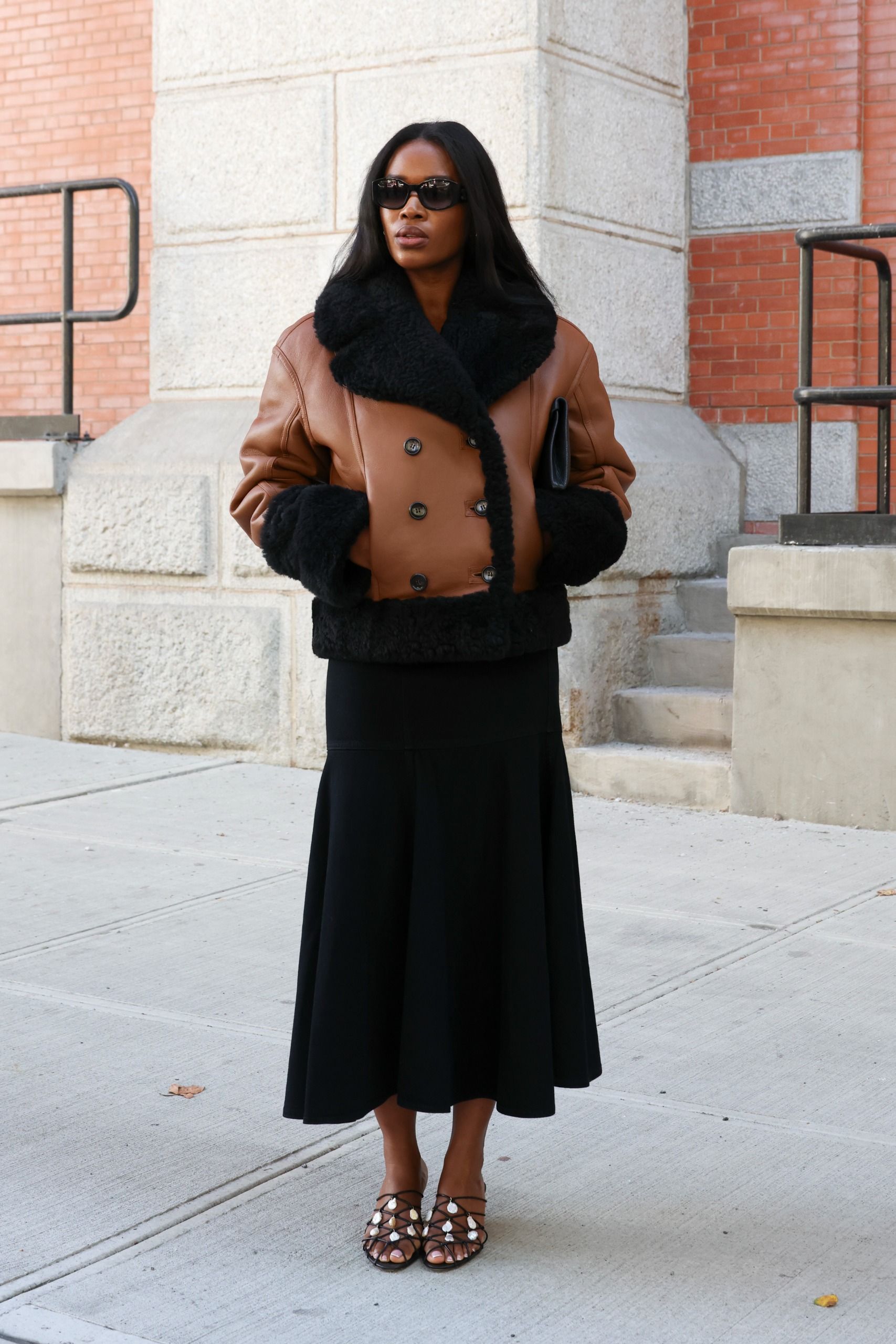 Woman in brown shearling jacket street style Fashion Week 