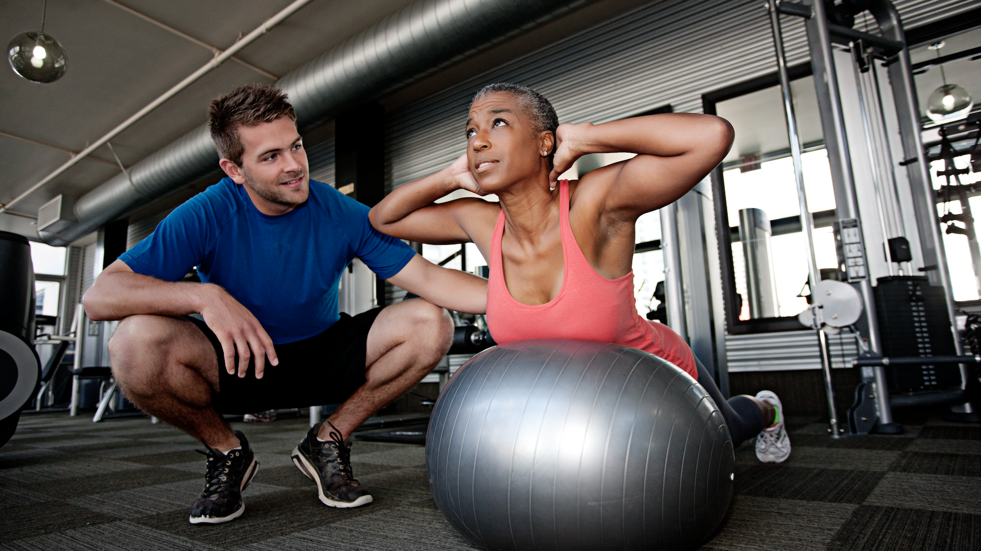 Woman training on a medicine ball with a personal trainer