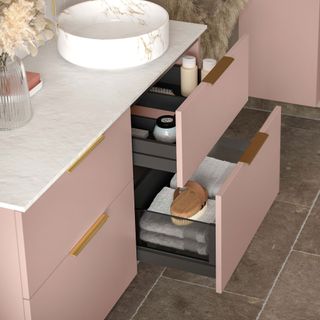 Pink vanity unit storage in drawers under sink in bathroom