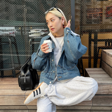 Influencer wears Adidas Tokyo trainers with a denim jacket and track pants.