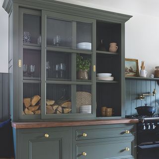 dark green glass kitchen dresser with sliding cabinet doors