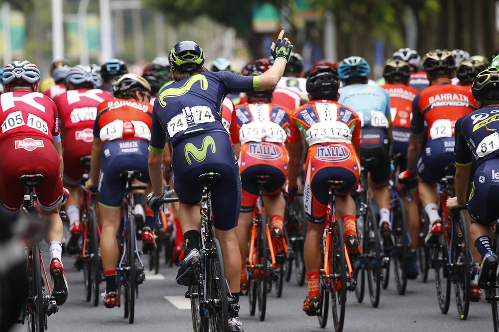 A Movistar rider raises his hand for assistance