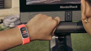 Someone wearing the Fitbit Charge 6 prepares for a workout with an exercise machine