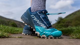 A close-up of a pair of feet wearing Dynafit Feline SL Running Shoes.