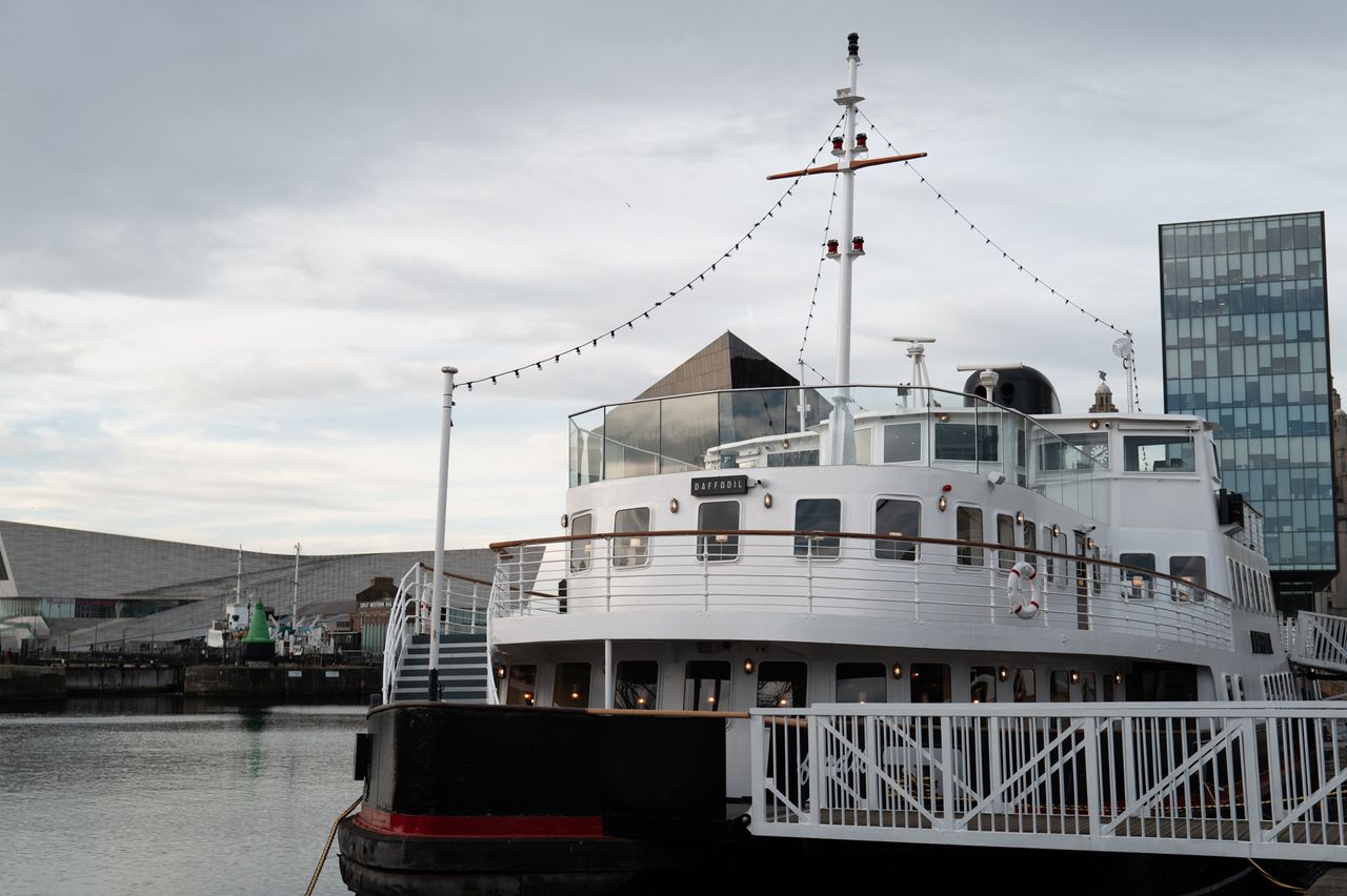 A pleasure boat docked in a marina waiting for passengers