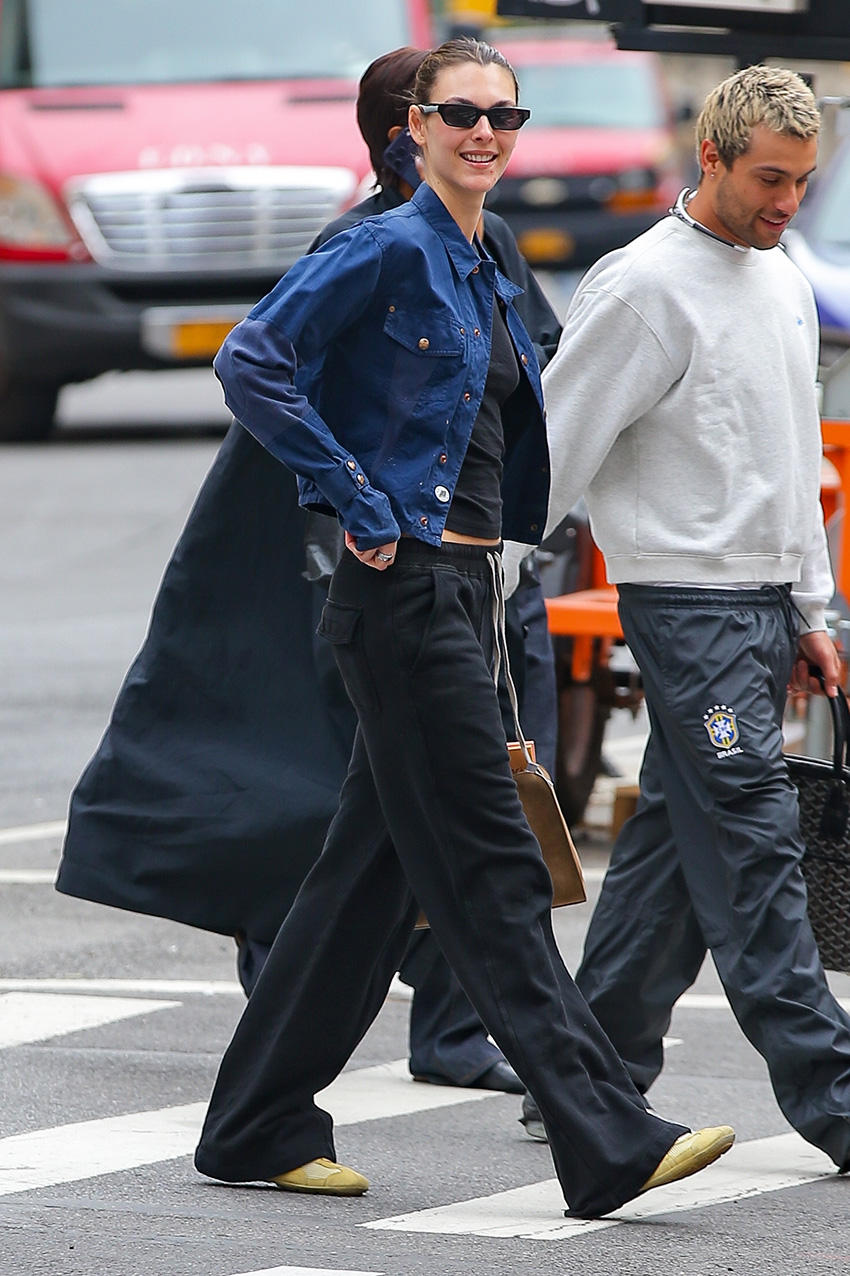 Vittoria Ceretti wearing a navy jacket and black T-shirt with black pull-on pants and butter yellow sneakers in NYC.