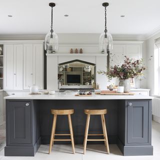 kitchen island with glass pendant lights and wood stools