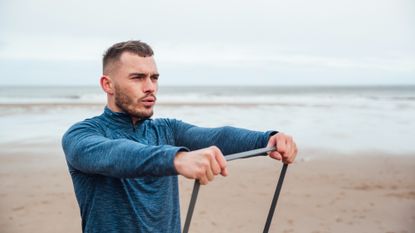 Man exercising outside with resistance bands