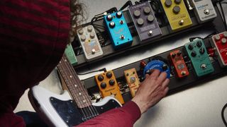 Man testing pedals on a pedalboard