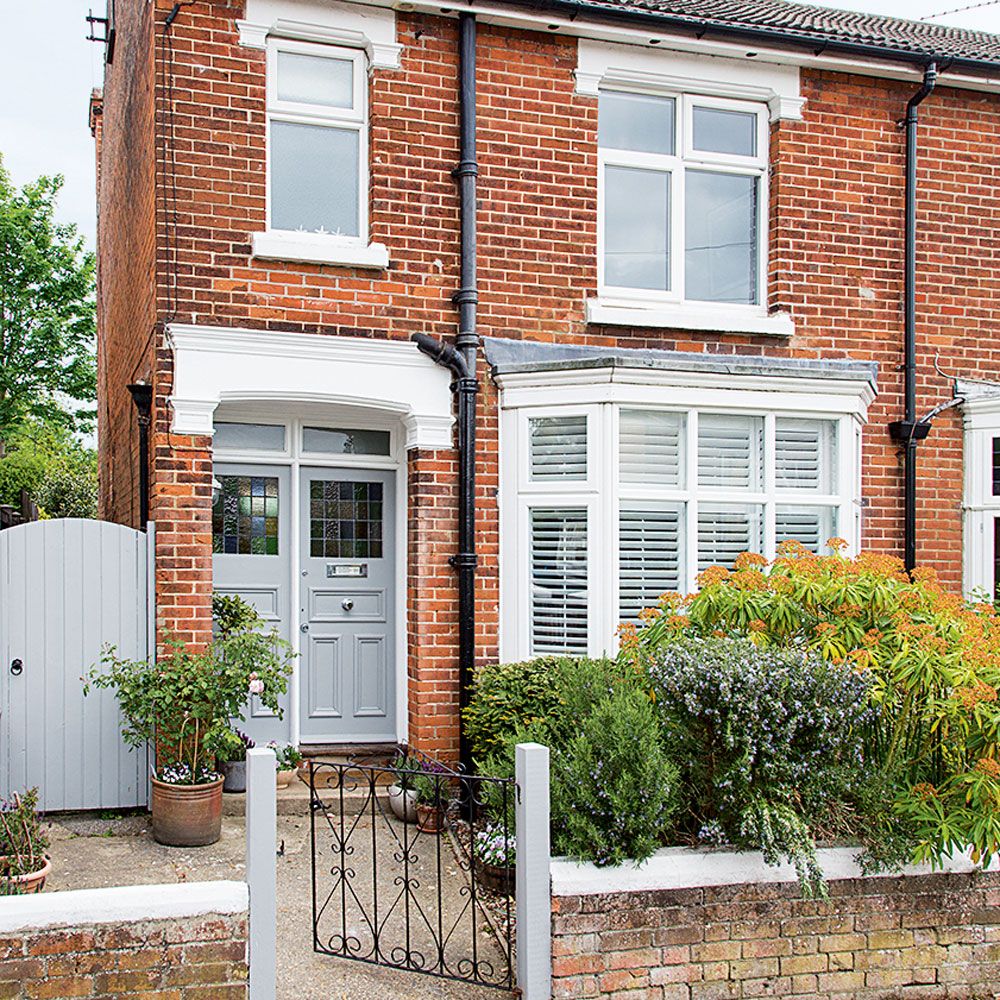 exterior of red brick house with pathway and bay window