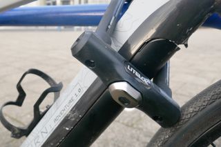 litelok x3 locking an e-bike to a bike rack, ensuring its battery is secured.