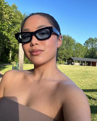 Woman wearing sunglasses with clear, glowing skin