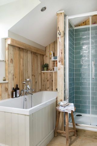 small bathroom with bath and shower enclosure with blue splashback tiles