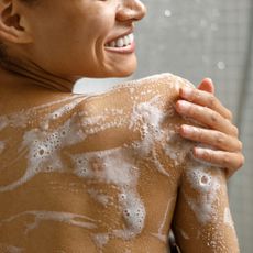 Best body washes - woman with lather all over her back in the shower - gettyimages 1451831969
