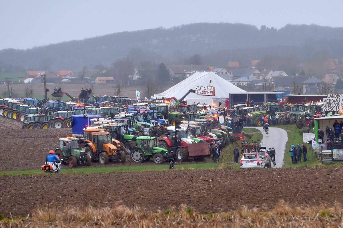 A protest of tractors flanks the road