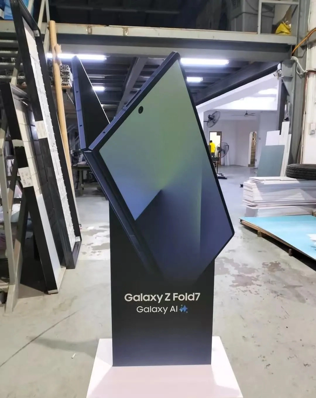 A leaked promotional standee for the Samsung Galaxy Z Fold 7 displayed in what appears to be a warehouse or manufacturing space.
