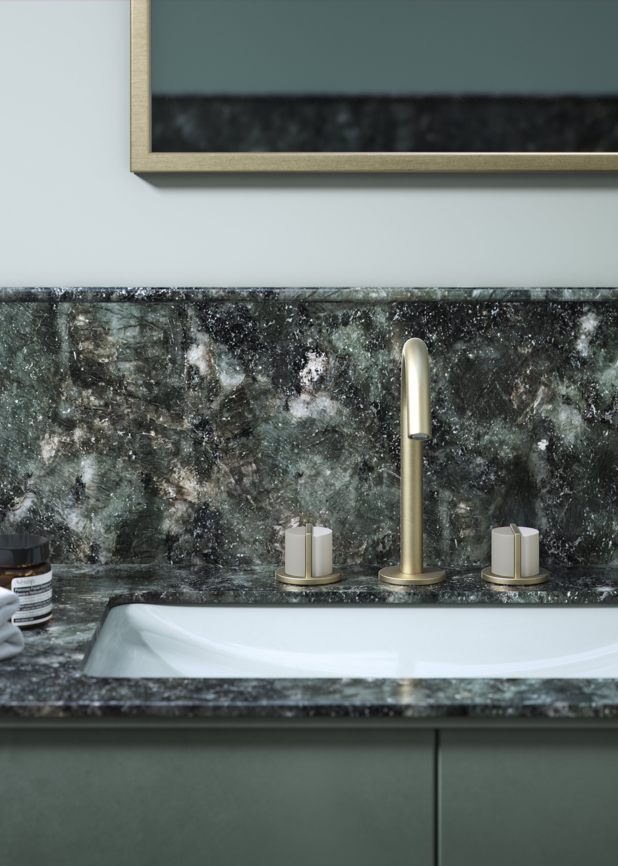 bathroom sink with gold brassware and a green marble counter and backsplash