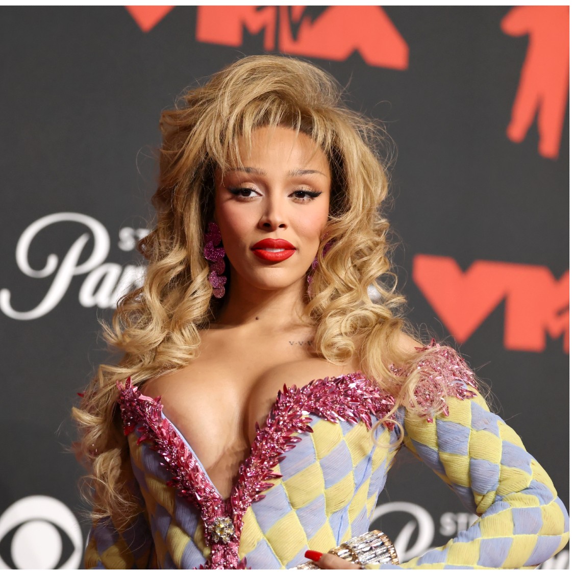 a photo of a woman with blonde hair with big curls and feather bangs