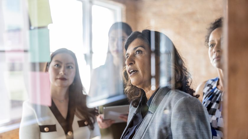 C-suite executives in an open plan office space discussing AI strategy plans.