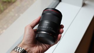 Canon RF 35mm f/1.4L VCM lens held in a hand