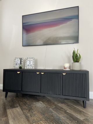 Black cabinet with fluted doors and gold handles